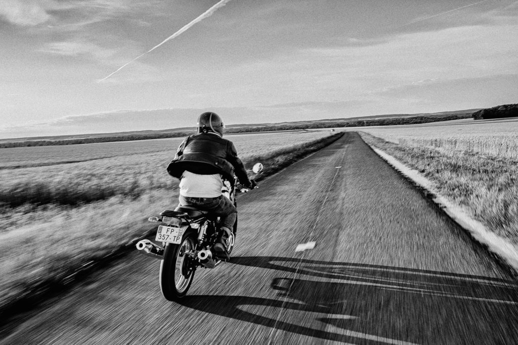 Motard qui roule sur une route déserte 